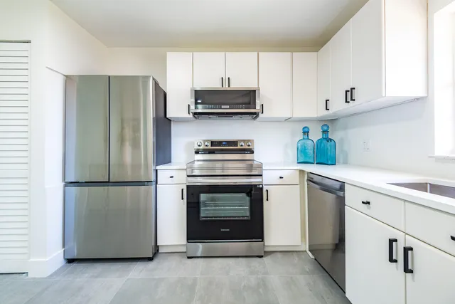 a kitchen with white cabinets and stainless steel appliances