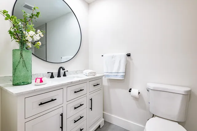 a bathroom with a sink vanity mirror and toilet