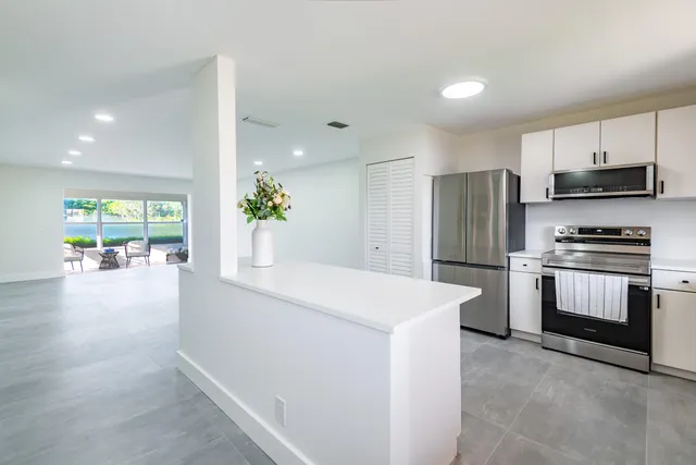 a kitchen with a refrigerator and a stove top oven