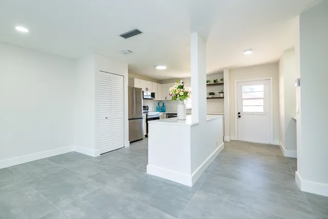 a view of a kitchen with refrigerator and a stove