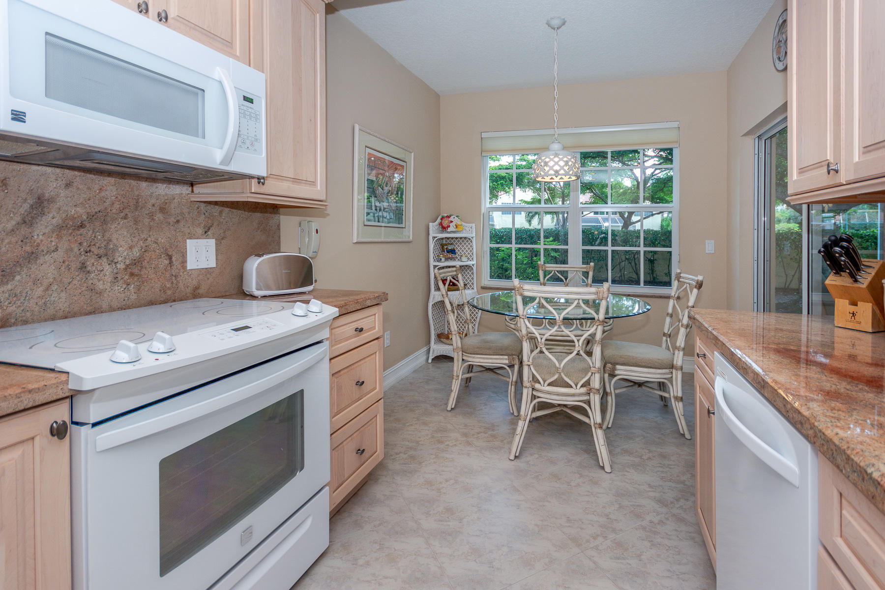 17050 Emile Street, Unit 4 Boca Raton, FL 33487 - Photo 16 of 32 a kitchen with a stove a sink and chairs