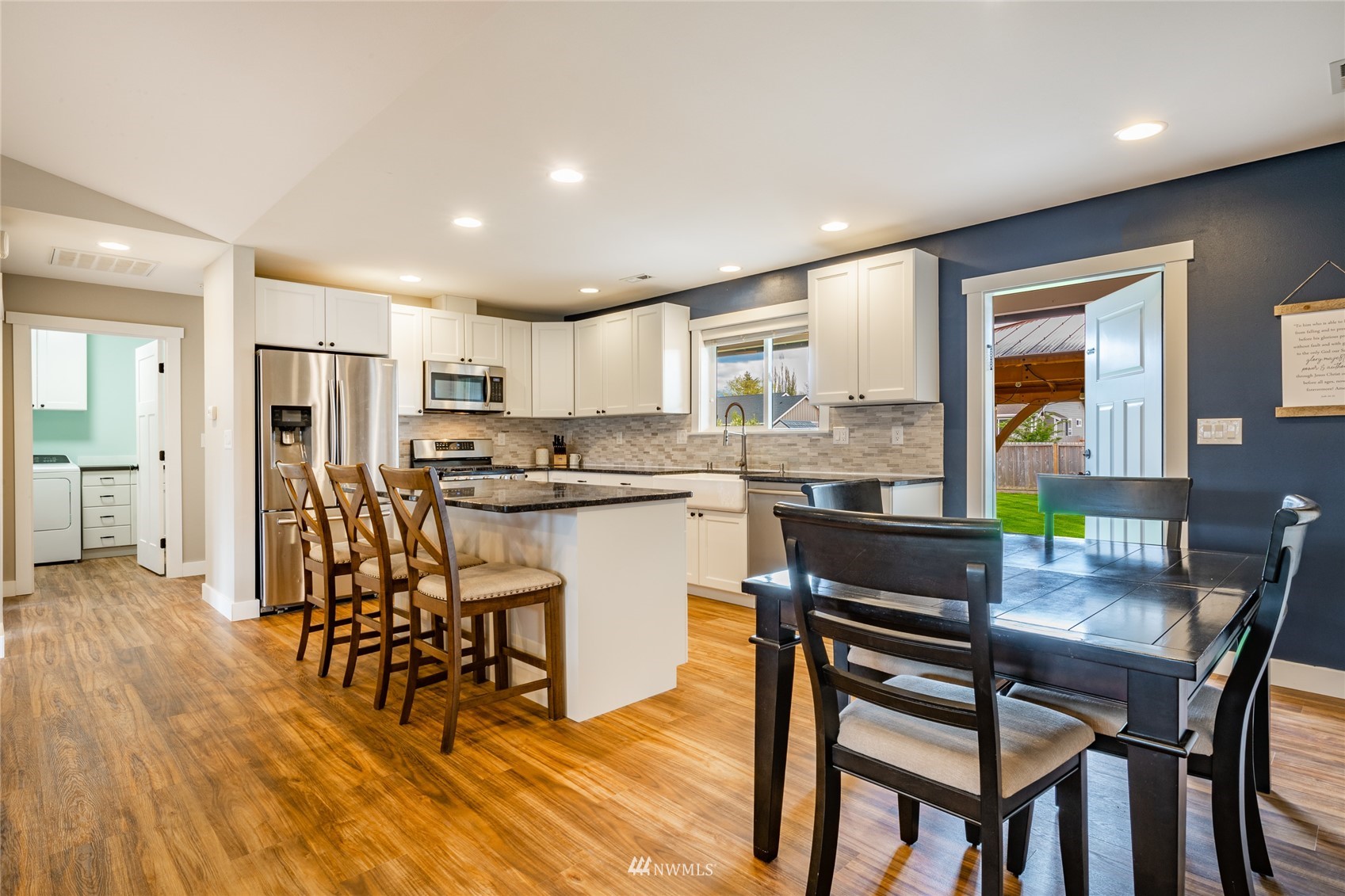 409 Amareen Court Nooksack, WA 98276 - Photo 7 of 35 a kitchen with stainless steel appliances a dining table chairs and granite counter tops