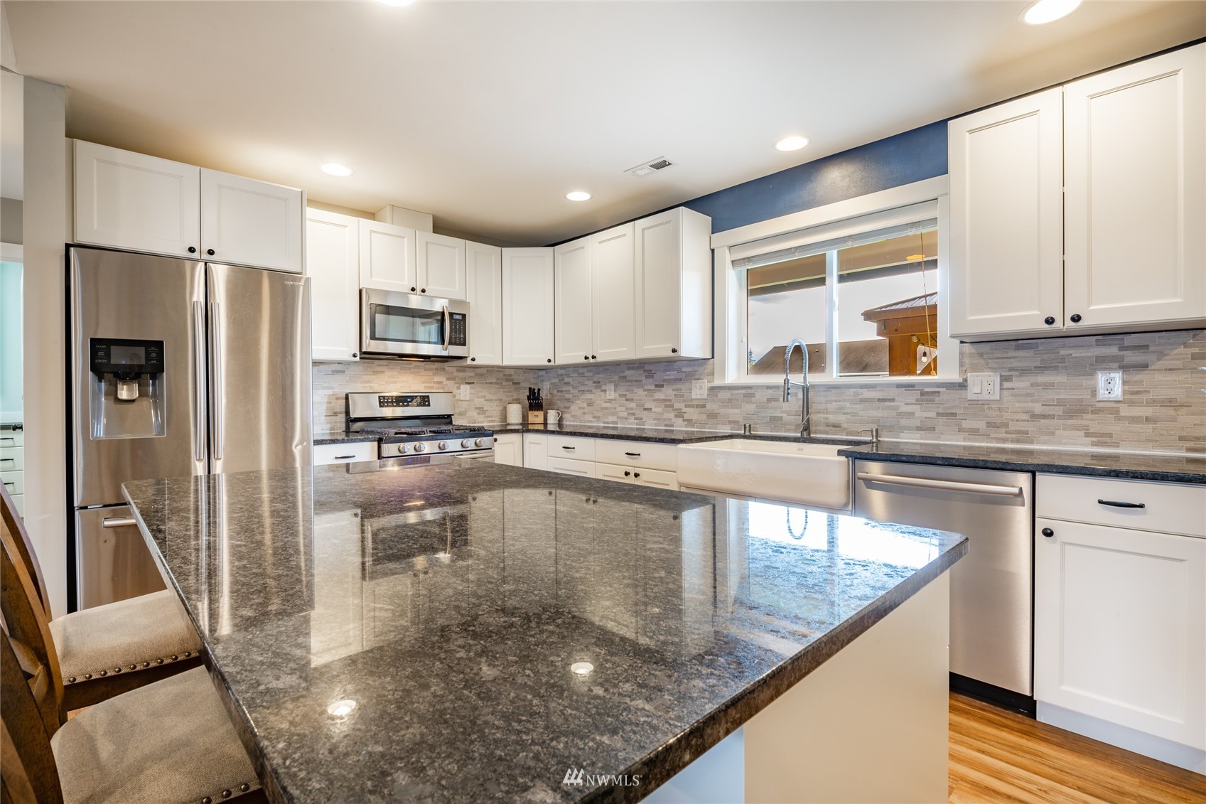409 Amareen Court Nooksack, WA 98276 - Photo 9 of 35 a kitchen with stainless steel appliances granite countertop a refrigerator a stove a sink a dining table and chairs