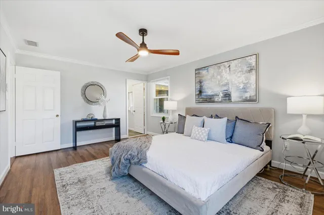 a bedroom with a bed a table and painting on the wall