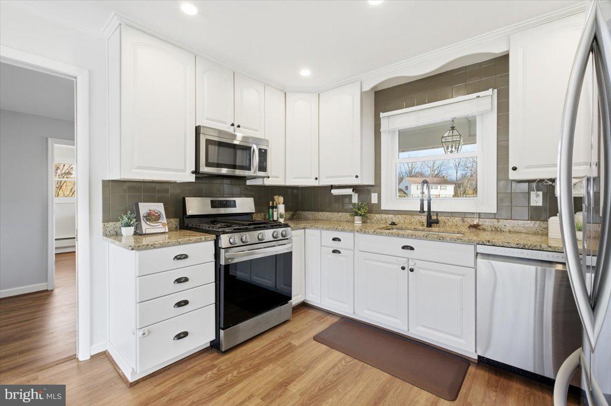 6906 Sprouse Court Springfield, VA 22153 - Photo 8 of 37 a kitchen with granite countertop a sink cabinets and stainless steel appliances