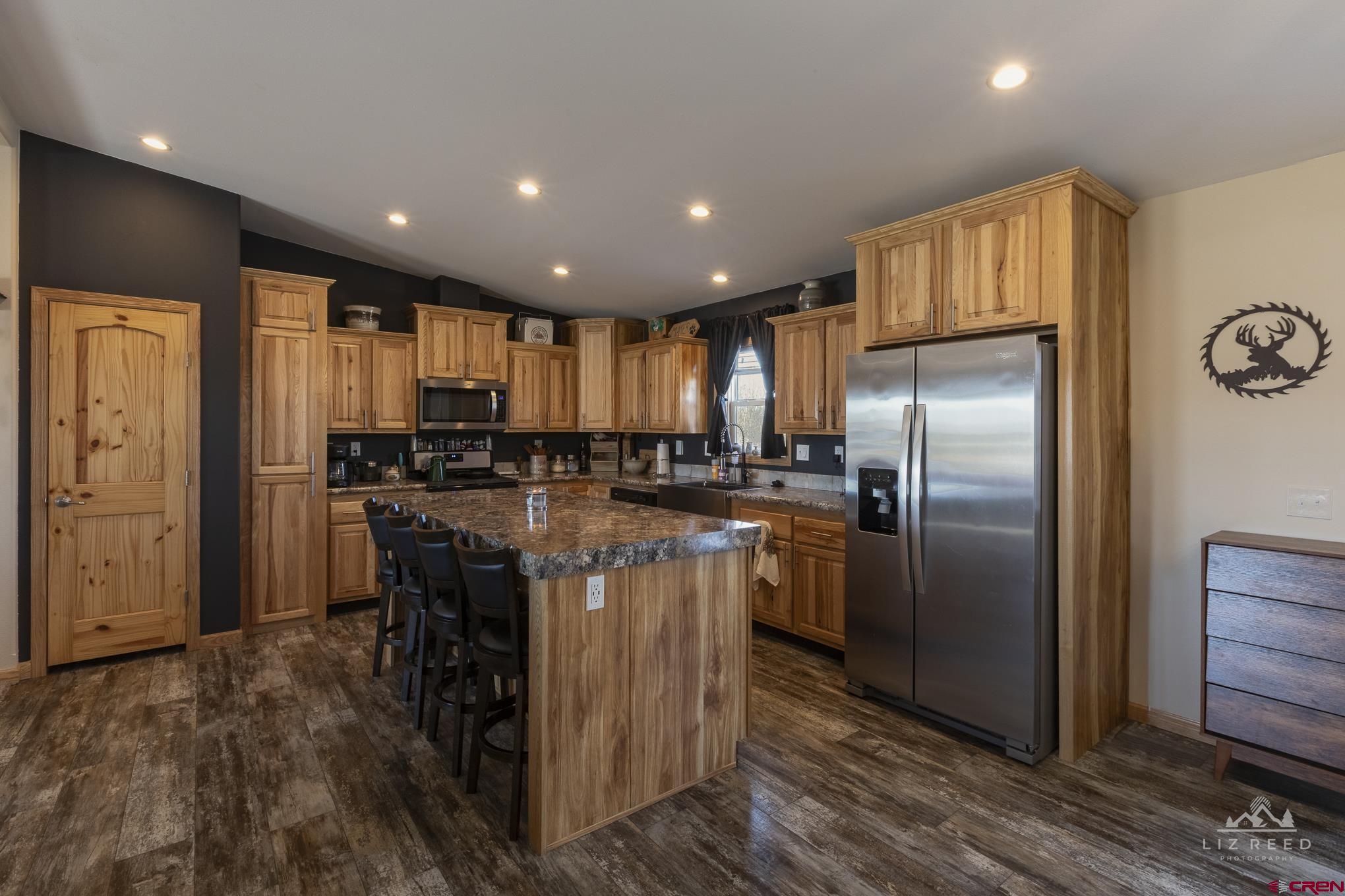 55339 Begonia Road Delta, CO 81416 - Photo 27 of 34 a kitchen with stainless steel appliances granite countertop a refrigerator a stove a sink a dining table and chairs with wooden floor