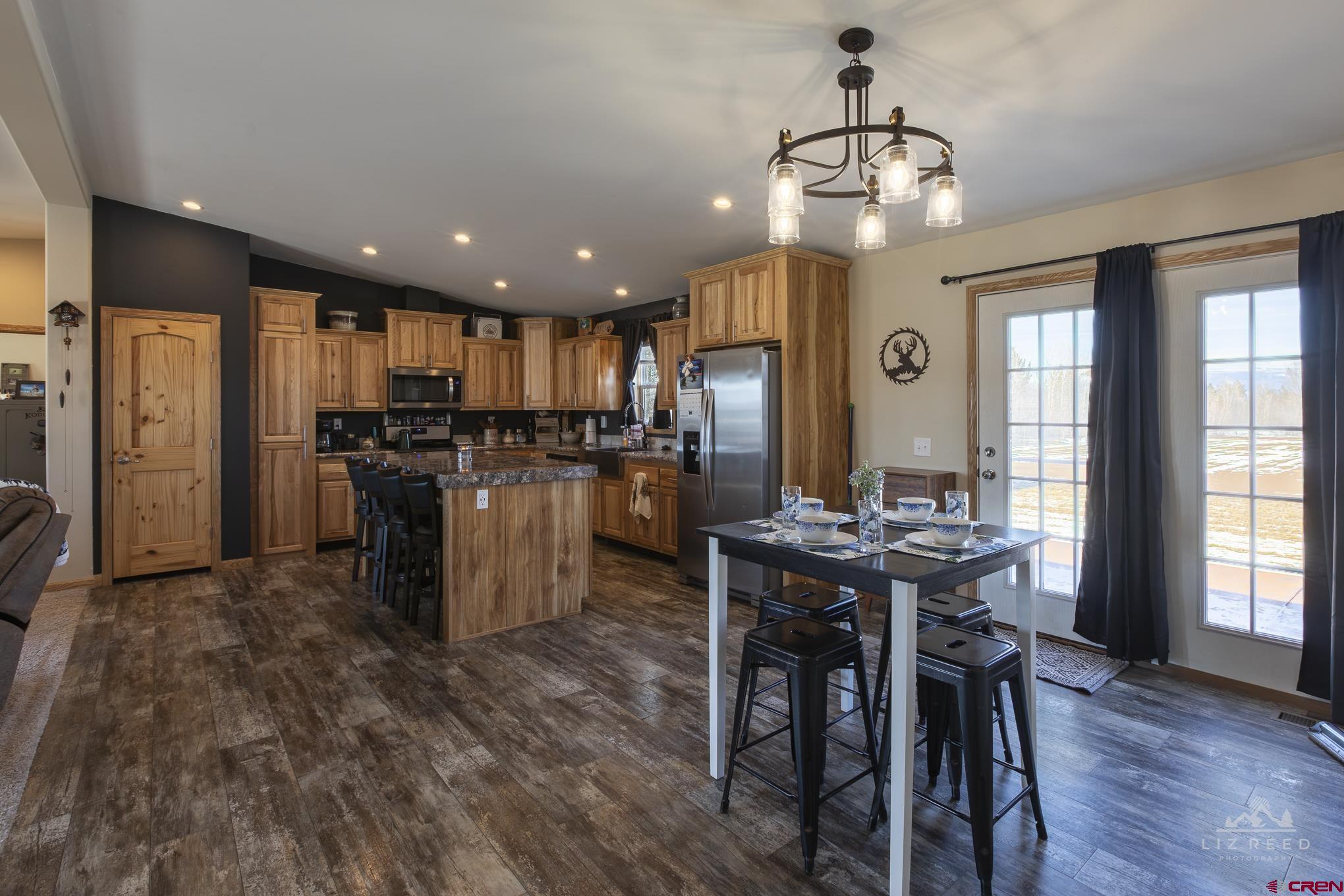 55339 Begonia Road Delta, CO 81416 - Photo 28 of 34 a kitchen with stainless steel appliances kitchen island granite countertop a refrigerator and a dining table