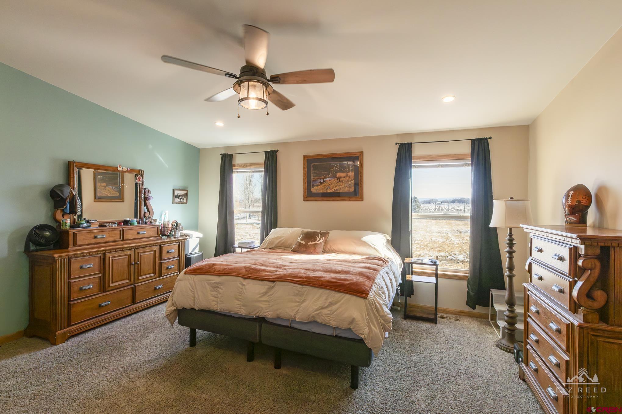 55339 Begonia Road Delta, CO 81416 - Photo 32 of 34 a bedroom with a bed and a chandelier