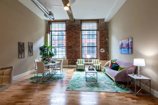 a living room with fireplace furniture and wooden floor
