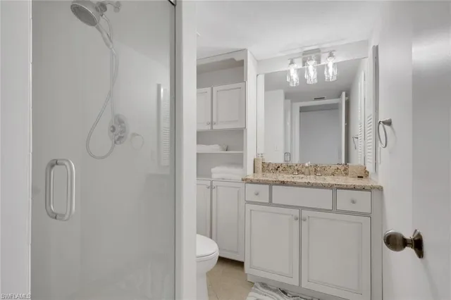 a bathroom with a granite countertop sink a toilet and a mirror