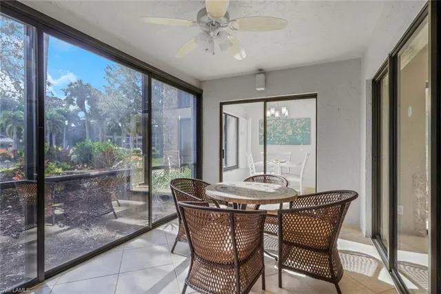 a dining room with furniture large windows and a chandelier