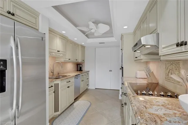 a kitchen with stainless steel appliances granite countertop a sink and a refrigerator