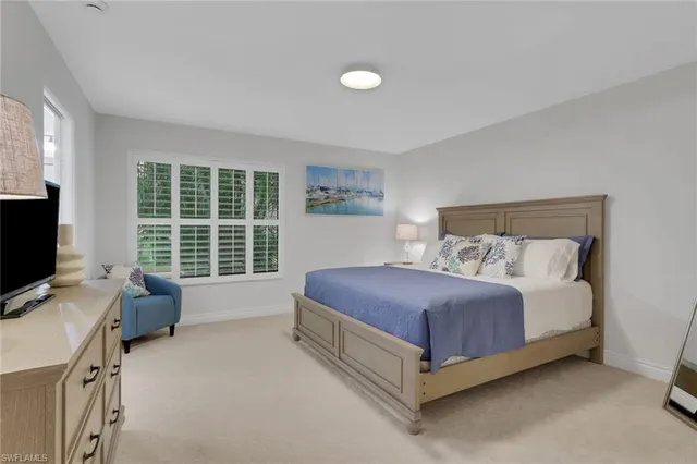 a spacious bedroom with a bed and glass window