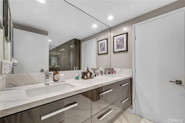 a bathroom with a glass shower door and sink