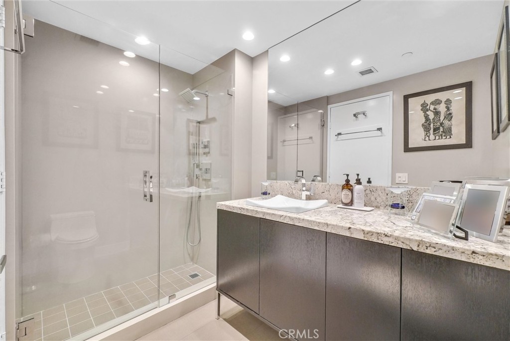 850 East Ocean Boulevard, Unit 1506 Long Beach, CA 90802 - Photo 16 of 58 a bathroom with a granite countertop sink a mirror and a shower