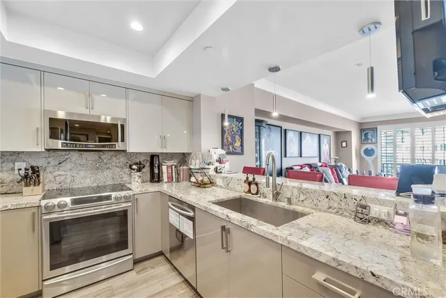 a kitchen with stainless steel appliances a refrigerator sink and stove