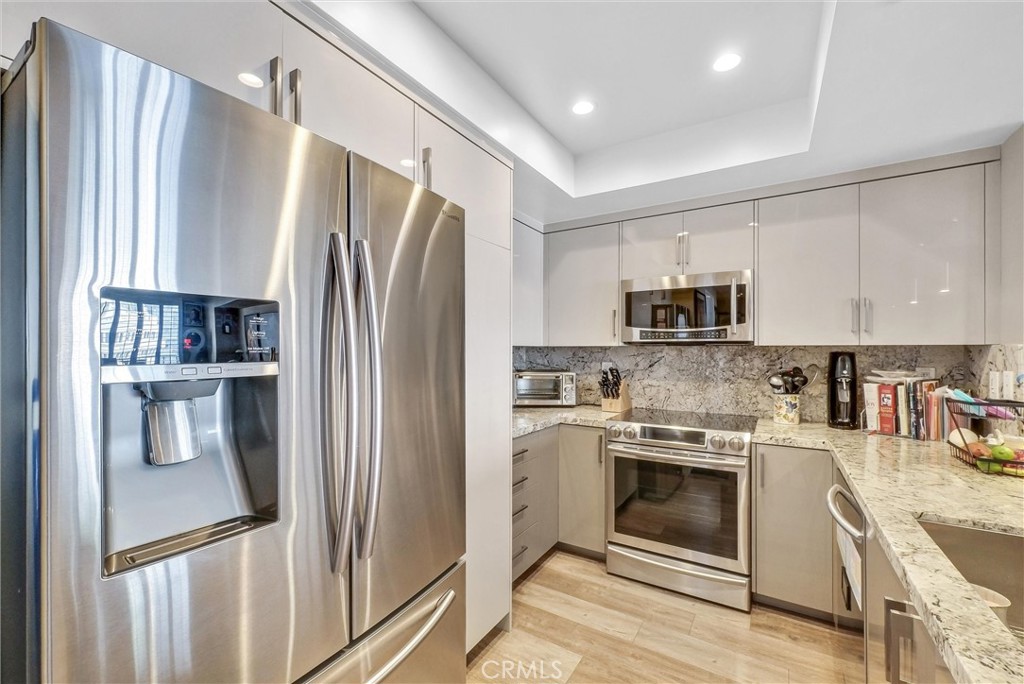 850 East Ocean Boulevard, Unit 1506 Long Beach, CA 90802 - Photo 9 of 58 a kitchen with stainless steel appliances a refrigerator sink and stove