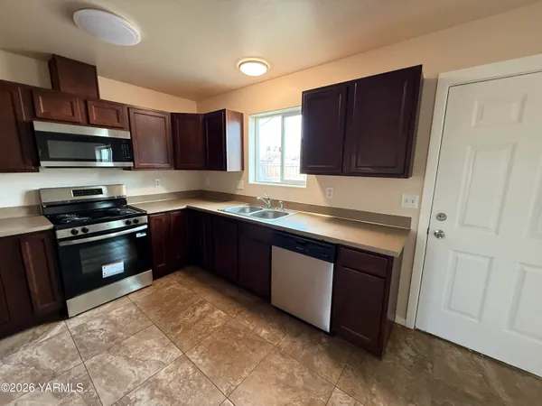 a kitchen with granite countertop a refrigerator and a sink