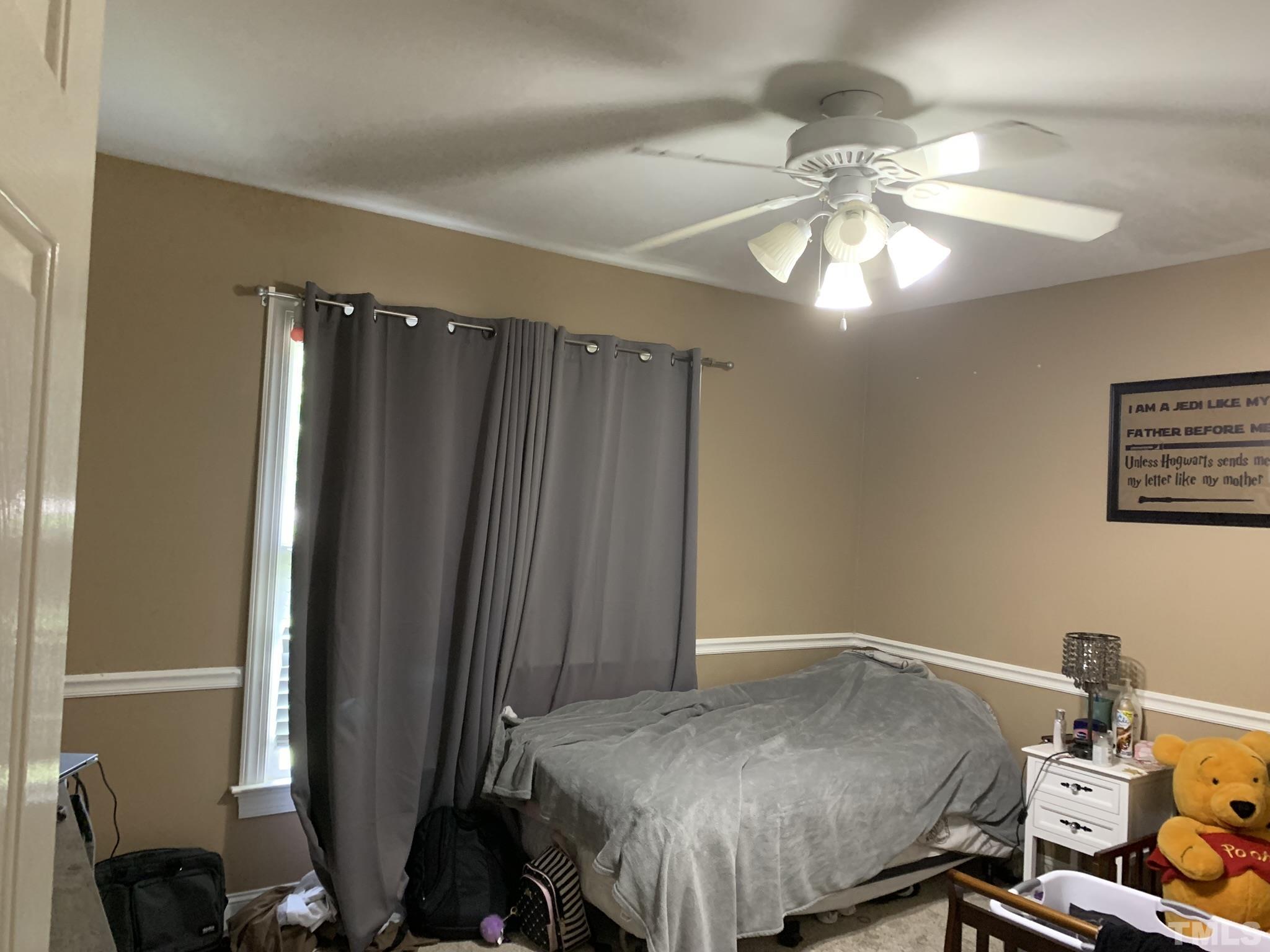 102 Younger Road Roxboro, NC 27573 - Photo 15 of 16 a bedroom with a bed and a chandelier