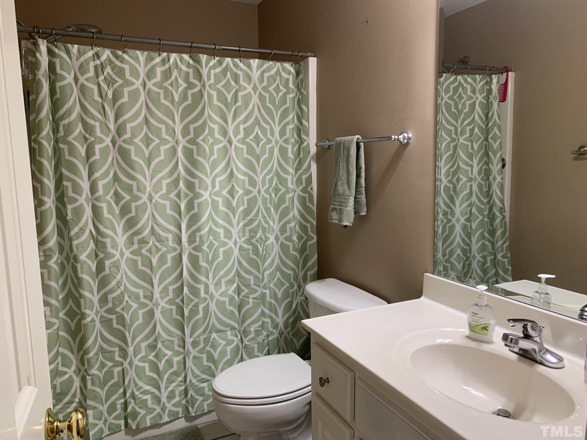 102 Younger Road Roxboro, NC 27573 - Photo 16 of 16 a bathroom with a sink a toilet and shower curtain