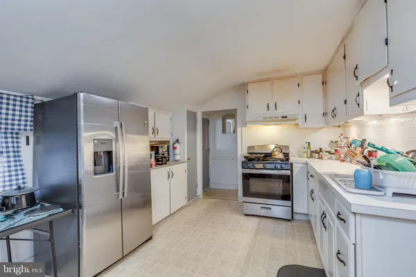a kitchen with refrigerator a stove and cabinets