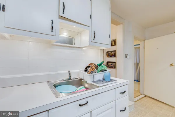 a kitchen with stainless steel appliances a white sink refrigerator and cabinets