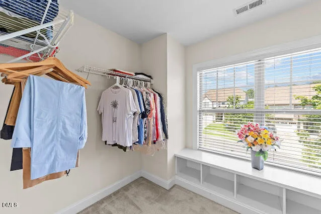 a view of walk in closet with clothes and shoes