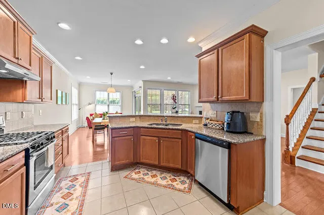 a kitchen with stainless steel appliances granite countertop a sink stove and cabinets