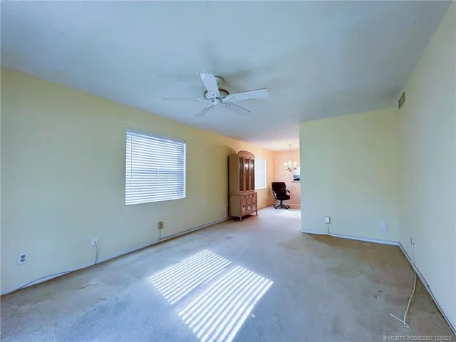 a view of a room with a ceiling fan and window