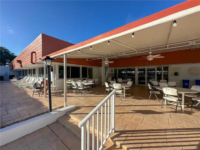 a view of a patio with table and chairs under an umbrella
