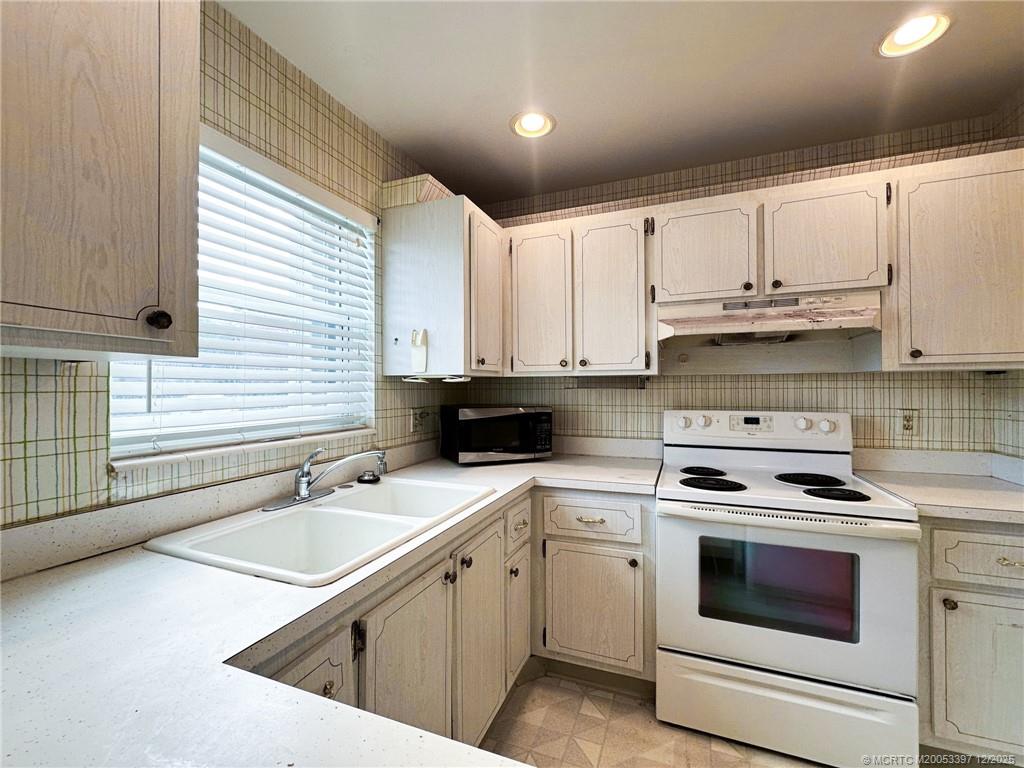 2600 Southeast Ocean Boulevard, Unit II1 Stuart, FL 34996 - Photo 9 of 38 a kitchen with stainless steel appliances granite countertop a sink a stove and cabinets