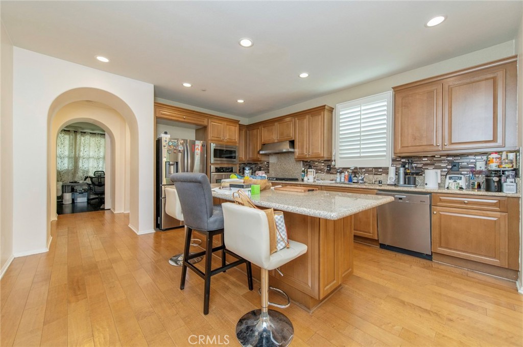 579 Boxwood Lane Azusa, CA 91702 - Photo 6 of 27 a kitchen with stainless steel appliances granite countertop a stove a sink dishwasher and a refrigerator with wooden floor