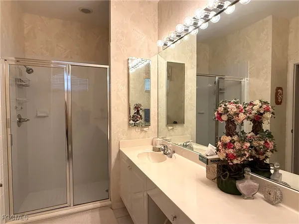 a bathroom with a sink mirror and shower