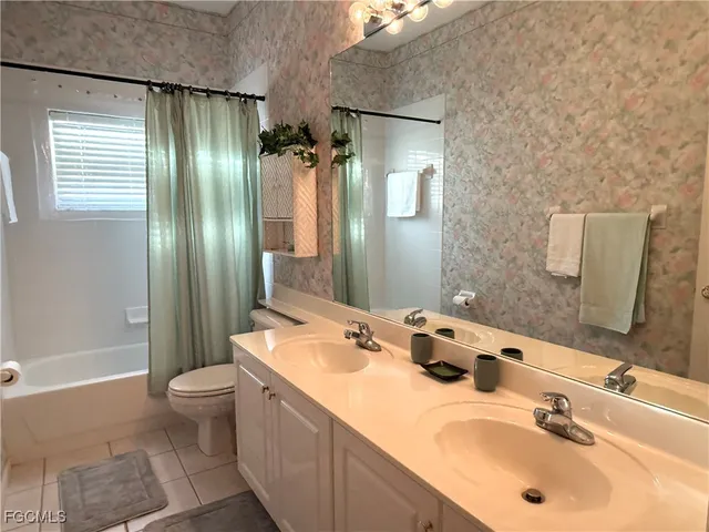 a bathroom with a double vanity sink toilet mirror and shower