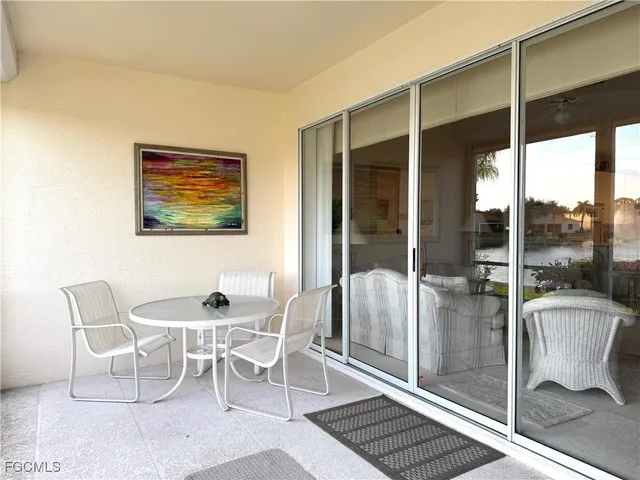 a dining room with furniture and a floor to ceiling window