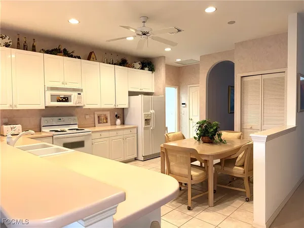 a kitchen with stainless steel appliances a stove a refrigerator sink cabinets and dining table