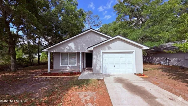 a view of a house with a yard and large tree