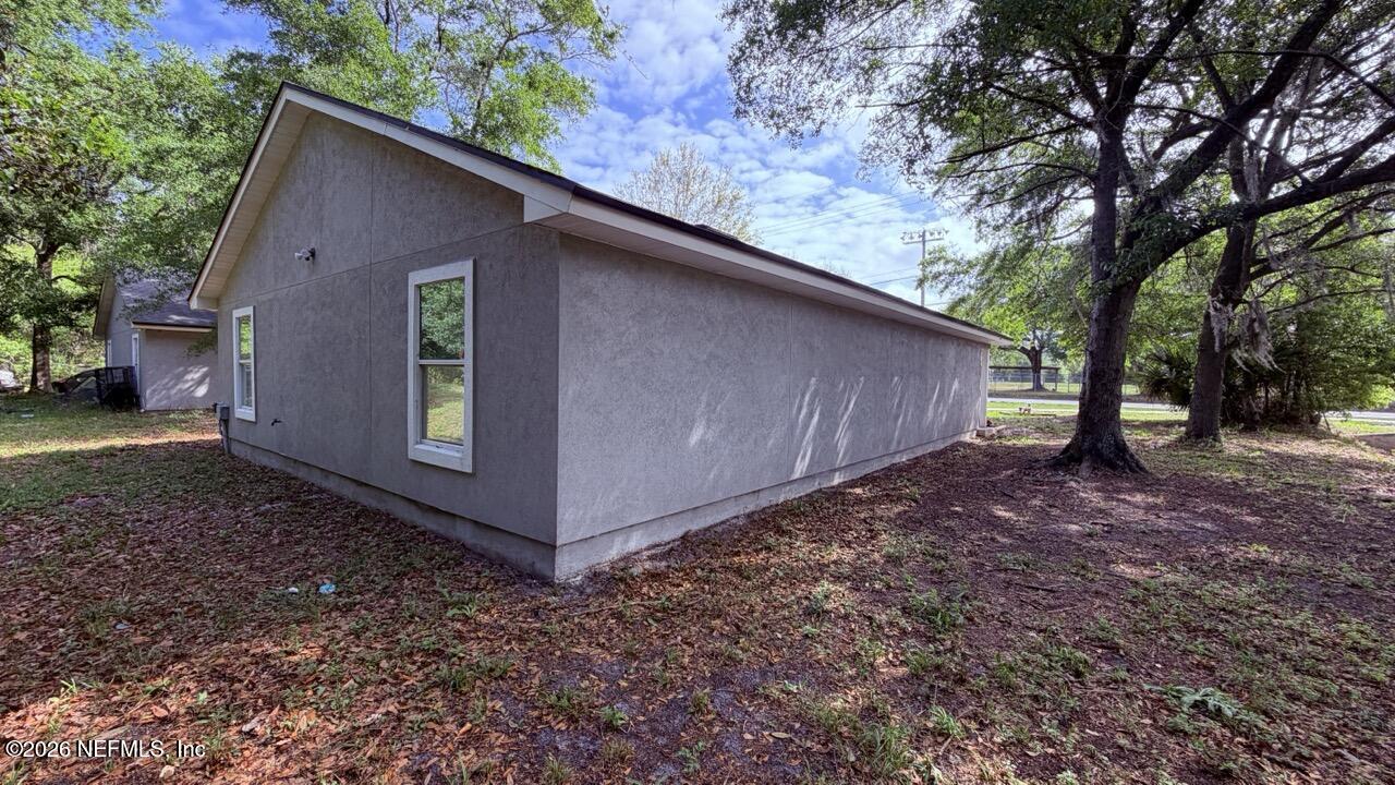 8678 Sibbald Road Jacksonville, FL 32208 - Photo 12 of 24 a backyard of a house with lots of green space