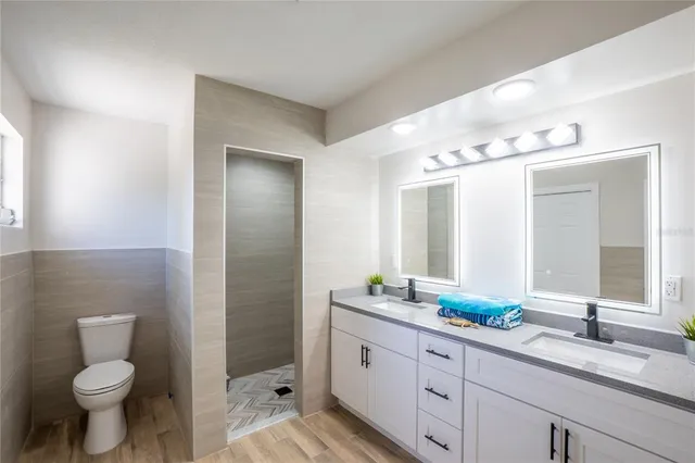 a bathroom with a double vanity sink toilet and shower