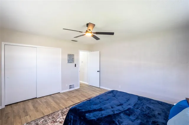a bedroom with a bed and a chandelier fan