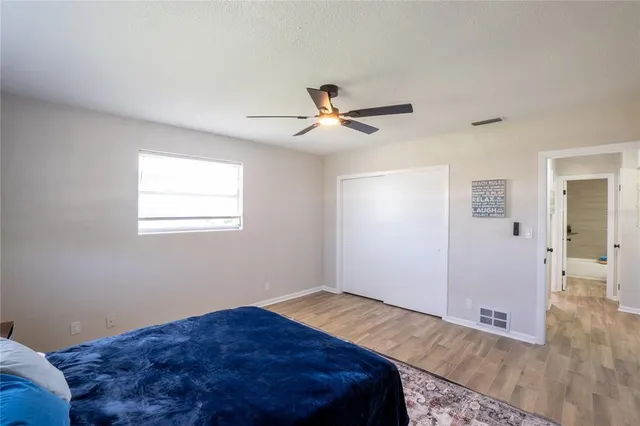 a bedroom with a bed and a chandelier fan