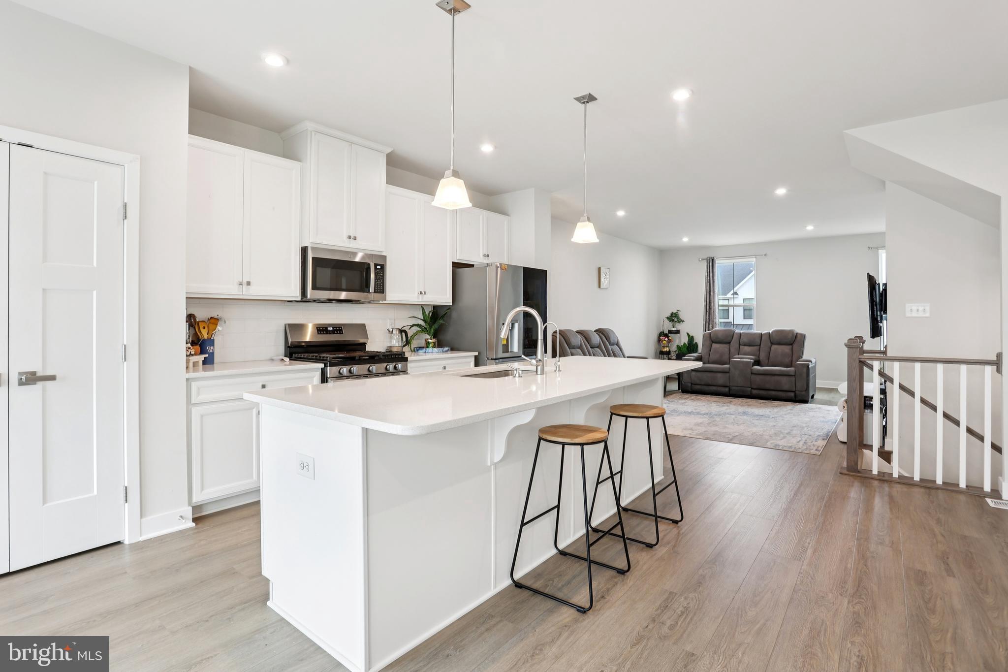 47 Rosemary Way Mount Laurel, NJ 08054 - Photo 18 of 47 a view of kitchen with microwave a stove a sink a refrigerator and white cabinets with wooden floor