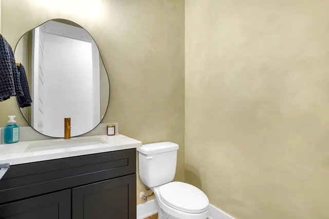 a bathroom with a toilet a sink and mirror