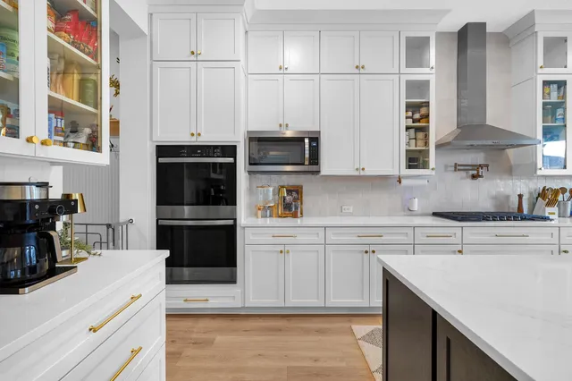 a kitchen with stainless steel appliances granite countertop a sink stove and cabinets