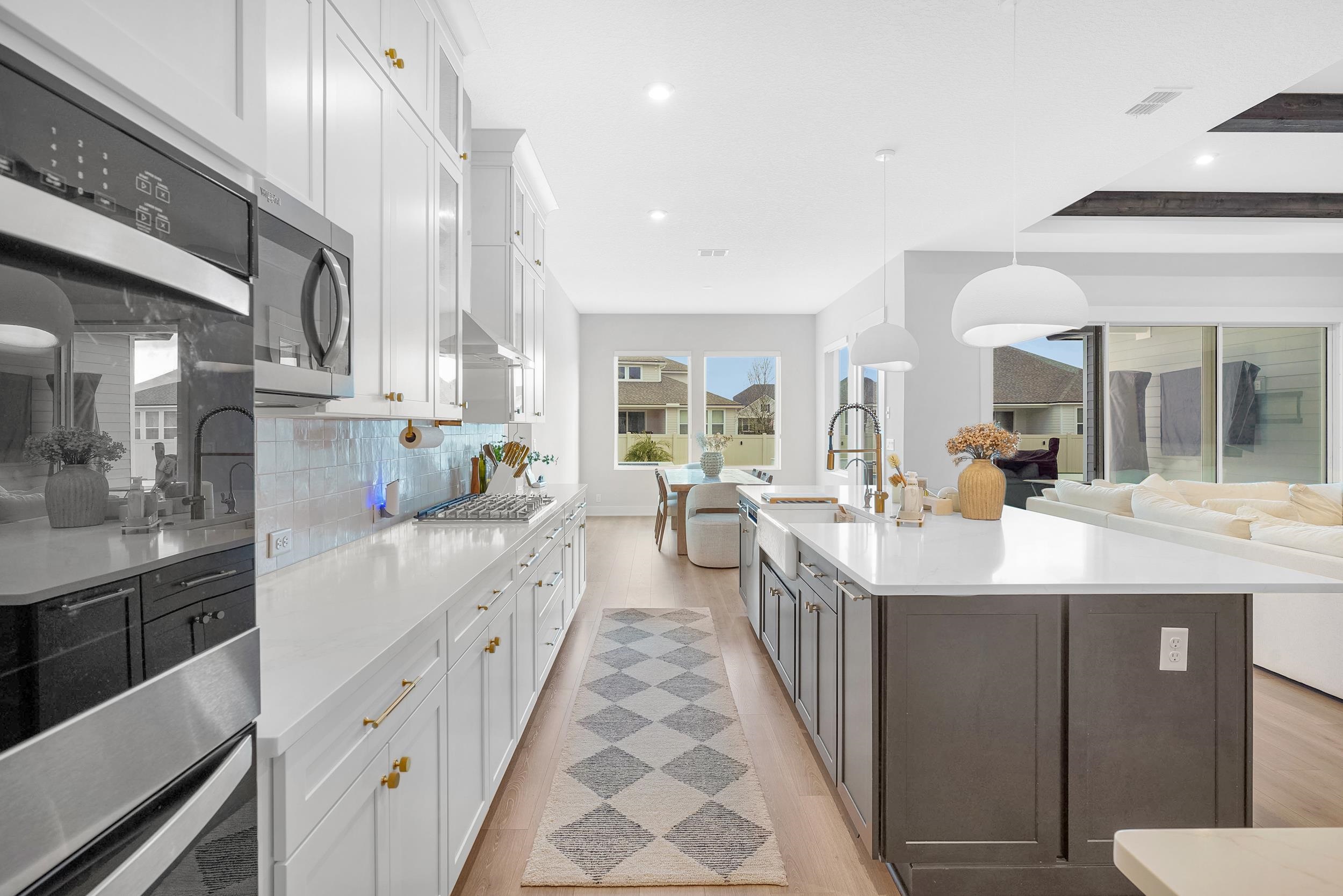 64 Oak Cluster Lane St. Augustine, FL 32092 - Photo 59 of 59 a large white kitchen with lots of counter space and a sink