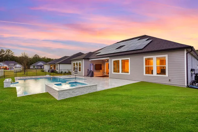 a view of a house with swimming pool and a yard
