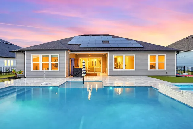 an aerial view of a houses with a swimming pool