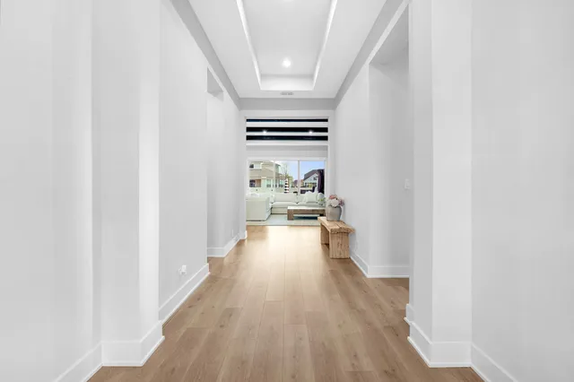 a view of a hallway with wooden floor and furniture