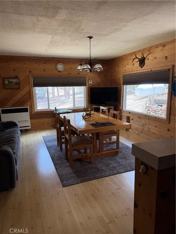 a living room with chairs a rug and a flat screen tv