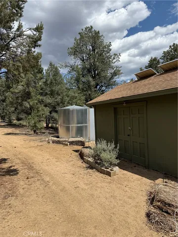 a view of dirt yard with a large tree